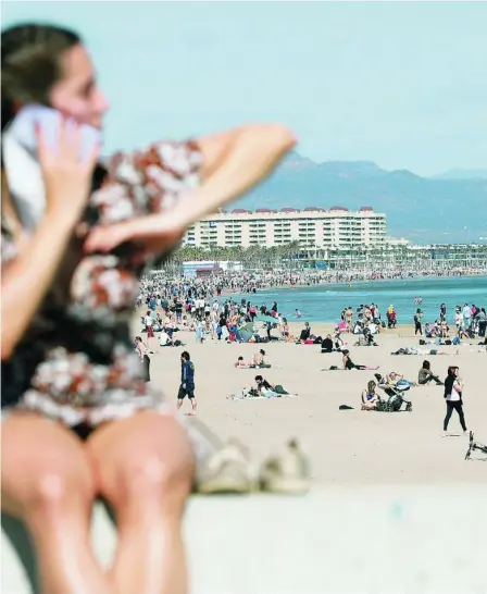  ?? EFE ?? Cientos de personas disfrutaro­n ayer del buen tiempo en la playa de la Malvarrosa (Valencia)