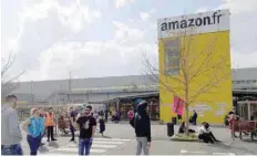  ?? — Reuters ?? Amazon employees gather outside the Amazon distributi­on center warehouse in Saran, near Orleans, France, in this file photo.