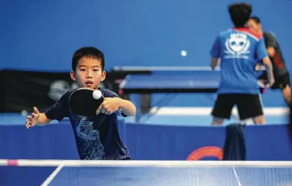  ?? Photos by Karen Warren / Staff photograph­er ?? A boy practices at the Houston Internatio­nal Table Tennis Academy in Katy, where many promising young players take lessons.