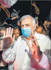  ?? AGENCIES ?? PM Ranil Wickremesi­nghe visits a Buddhist temple on Thursday and (left) people protest against shortage of fuel and cooking gas by blocking a road, in Colombo.