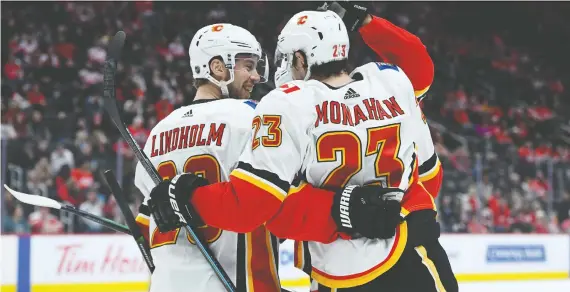  ?? TIM FULLER/ USA TODAY SPORTS ?? The Flames’ Sean Monahan celebrates with teammate Elias Lindholm after scoring against the Red Wings in the first period of Sunday’s game in Detroit.