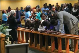  ?? Jacksonvil­le. Photograph: John Raoux/AP ?? Church members at the St Paul AME church pray with four Edward Waters University students, center, that attended a prayer service for the victims of a mass shooting, Sunday, in
