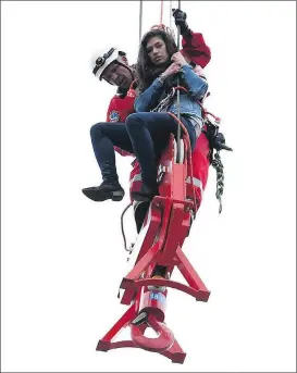  ?? FRANK GUNN, THE CANADIAN PRESS ?? Toronto firefighte­r Rob Wonfor helps Marisa Lazo to safety Wednesday after she got stuck on a crane in downtown Toronto.