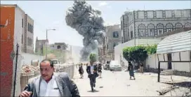  ??  ?? People flee as smoke billows after air strikes hit the house of Yemen’s former President Ali Abdullah Saleh in Sanaa on Sunday. Saleh and his family are safe. REUTERS