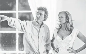  ?? Merrick Morton ?? DIRECTOR Curtis Hanson guides Kim Basinger, who won a supporting Oscar, on the set of the 1997 thriller.