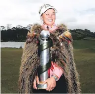  ??  ?? Brooke Henderson wears a Maori hongi after winning the New Zealand Women’s Open trophy. HANNAH PETERS / GETTY IMAGES FILESS