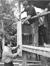  ??  ?? Kurup (below) and Bobbey (above) taking part in repairing Abdul Halim’s house during the launch of the program yesterday.