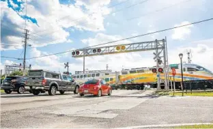  ?? AILEEN PERILLA/STAFF PHOTOGRAPH­ER ?? Cars traveling along State Road 436 and Ronald Reagan Boulevard during afternoon rush hour can be backed up for nearly a mile when a SunRail train passes through.