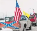  ?? JACOB HAMILTON/ THE BAY CITY TIMES VIA AP ?? Trucks bearing Confederat­e flags and other banners are parked outside Bay City Western High School.