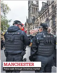  ??  ?? Police walk through Christmas market