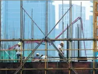  ?? ZHOU CHANGGUO / FOR CHINA DAILY ?? Builders work at a property constructi­on site in Huai’an, Jiangsu province.