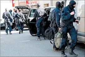  ?? ERIC CABANIS/GETTY-AFP ?? French forces gather outside a supermarke­t Friday in Trebes, a town in southern France, where a man took hostages before police units moved in. Sixteen people were injured.