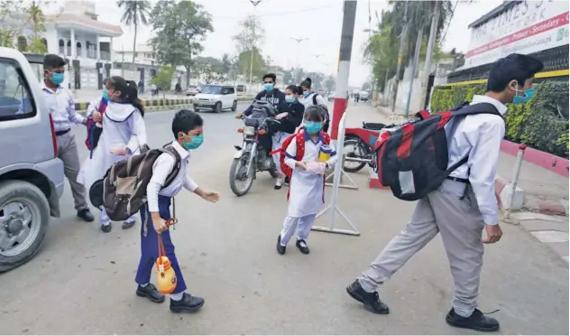  ?? Associated Press ?? ↑
Students arrive at their school in Karachi on Tuesday.