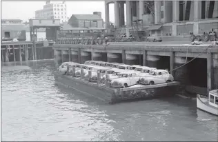  ?? PHOTOS COURTESY VANCOUVER PUBLIC LIBRARY ?? A barge loaded with 22 new Austin A40 cars is ready to take them to a watery grave in Vancouver’s English Bay on May 9, 1952.