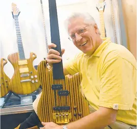  ?? MORNING CALL FILE PHOTO ?? Dick Boak, former head of artist relations at Martin Guitar in Nazareth, holds an exotic wood electric bass he made in 1980.