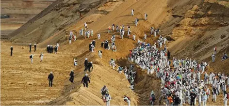  ?? FOTO: GETTY ?? Aktivisten in weißen Overalls versuchten gestern, das Herz des Tagebaus Hambach zu erreichen. Hier arbeiten die längsten Bagger (220 Meter) der Welt.