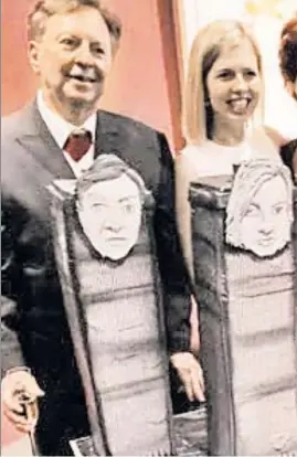  ??  ?? TASTELESS CAKE: Jerry Casale (inset, with Devo) and bride Krista Napp smile behind their “Twin Towers of Love” wedding cakes.