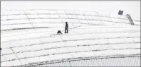  ?? CP PHOTO ?? Workers examine a hole in top of the Rogers Centre as the area around the CN Tower was closed off due to reports of falling ice Monday in Toronto.