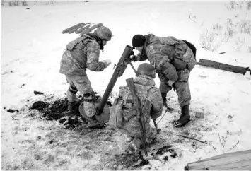  ?? AGENCE FRANCE PRESSE ?? Ukrainian servicemen of the State Border Guard Service prepare to fire a mortar toward the Russian position in Bakhmut on February 16, 2023, as the head of Russia’s mercenary outfit Wagner said it could take months to capture the embattled Ukraine city and slammed Moscow’s “monstrous bureaucrac­y” for slowing military gains.