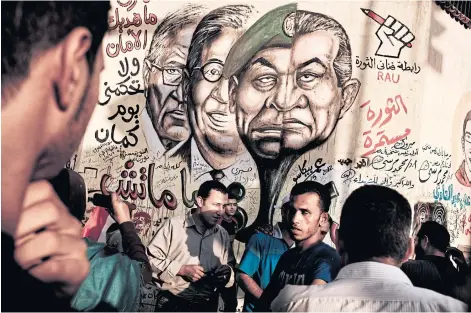  ??  ?? A mural in Cairo’s Tahrir Square after Egypt’s revolution depicts ousted President Hosni Mubarak and his former ministers on June 25, 2012.