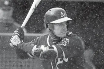  ?? CHARLIE RIEDEL/AP PHOTO ?? Oakland’s Mark Canha waits in the rain for a pitch during the first inning of Friday’s spring training game against Seattle in Peoria, Ariz.