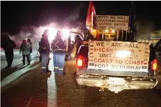  ??  ?? Supporters of a truck convoy headed to Ottawa have a chat near the Prairie Oasis motel in Moose Jaw. The convoy, which pulled out of Red Deer, Alta. on Thursday morning, expects to make it to Parliament Hill by Feb. 19.