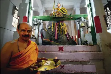  ??  ?? Le prêtre brahman donne l’onction et reçoit les offrandes au temple de Nandi, le taureau divin du dieu Shiva. Nandi est particuliè­rement vénéré en Inde du Sud.