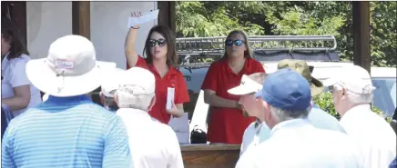  ?? ?? Lindsay Midkiff, left, and Carly Dillard, with East Arkansas Community College, give instructio­ns to golfers before play began in Monday’s 11th annual golf tournament to benefit the college’s foundation. Fifteen teams played in the tournament held at the Forrest City Country Club.