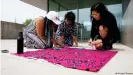  ?? ?? На мастер-классе Арам Хан Сифуэнтес участницы фестиваля учатся использова­ть технику аппликации для создания протестных баннеров