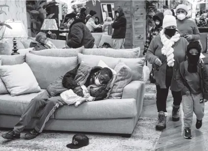  ?? Brett Coomer / Staff photograph­er ?? People gather at a warming shelter set up at a Gallery Furniture store on Tuesday in Houston.