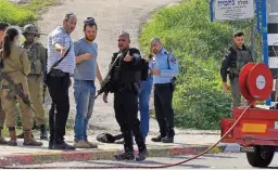  ?? (AFP) ?? Israeli security forces gather at the site where a Palestinia­n man attempted to stab an Israeli solder with a knife before being shot dead, near the Kdumim settlement, in the occupied West Bank, on Wednesday