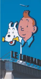  ?? AP FILE PHOTO ?? A six-metre high depiction of Belgian cartoon hero Tintin and his dog Snowy is seen atop the Lombard Building in Brussels in 2011. The adventurou­s cartoon reporter turns 90 years old this year.