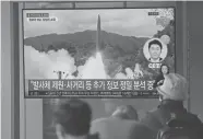  ?? LEE JIN-MAN/AP ?? People at a train station in Seoul, South Korea, watch a news program reporting about North Korea’s missile launch Tuesday. File footage was used in the report.