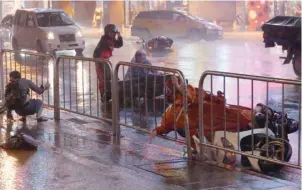  ?? — Reuters ?? A man and motorcycli­st fall as Typhoon Nesat hits Taipei on Saturday.