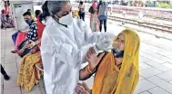  ??  ?? A health worker collects swab sample of a passenger at Dadar station in Mumbai on Saturday