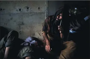  ?? ?? Afghans sit under a bridge Sept. 30 to consume drugs in Kabul.