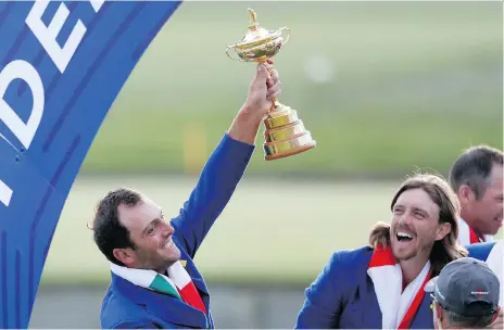  ?? ALASTAIR GRANT/THE ASSOCIATED PRESS ?? Europe’s Francesco Molinari holds up the Ryder Cup following his team’s decisive win in France Sunday.