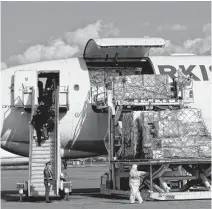  ?? PAVEL MIKHEYEV • REUTERS ?? Workers wearing protective gear unload a shipment of medical supplies from Turkey intended to combat the spread of COVID-19 from a cargo plane arrived at Almaty Internatio­nal Airport, Kazakhstan on April 18.