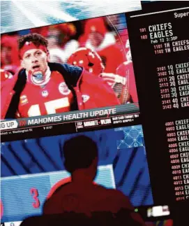  ?? John Locher/Associated Press ?? A person gambles as betting odds for the Super Bowl next Sunday are displayed on monitors at Circa Resort & Casino Las Vegas, which has a sportsbook.