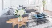  ?? TNS ?? A large charcoal sectional makes a powerful statement when paired with a gray-toned area rug.