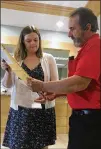  ?? PATRICK WHITTLE / AP ?? Courier John Campbell receives election results from City Clerk Angela Holmes on June 14 in Westbrook, Maine. Maine held the first statewide ranked choice voting primary in American history. Voters rank candidates from most to least preferred. A winner...