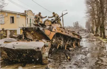  ?? DANIEL BEREHULAK/THE NEW YORK TIMES ?? Ukrainian soldiers salvage parts from a Russian military vehicle on April 3 in Bucha.