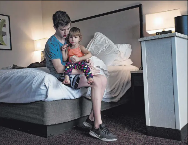  ?? Rachel Aston Las Vegas Review-Journal @rookie__rae ?? Weston Monson, 12, holds his sister Dixie, 2, at their family’s hotel room at the Suncoast. The Monson family were evicted from their Summerlin home in July 2018.