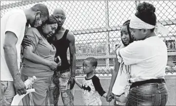  ?? ABEL URIBE/CHICAGO TRIBUNE ?? Jorgetta Martin, center, is hugged by Sherell Cole, left, and Zachary Smith at the West 69th Street overpass Saturday.