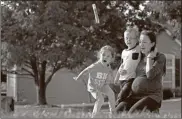  ?? Ap-charlie Riedel ?? Claire Reagan plays with her kids Evan, 5, and Abbie, 3, outside her home in Olathe, Kan. Reagan is keeping her son from starting kindergart­en and her daughter from preschool due to concerns about the coronaviru­s pandemic.