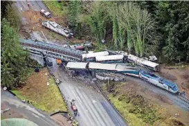  ?? [PHOTO BY BETTINA HANSEN, THE SEATTLE TIMES VIA AP] ?? Cars from an Amtrak train that derailed lie spilled onto Interstate 5 on Monday in DuPont, Wash. The Amtrak train making the first-ever run along a faster new route hurtled off the overpass Monday near Tacoma.