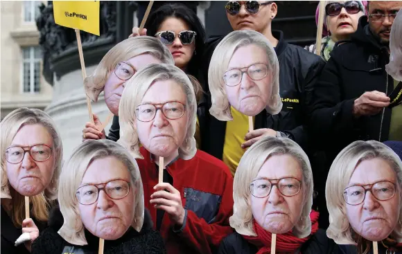  ?? (Gonzalo Fuentes/Reuters) ?? ACTIVISTS WEAR masks depicting the face of Jean-Marie Le Pen, the founder of the French far-right National Front, with the hair of current party leader, his daughter Marine Le Pen, during a demonstrat­ion last year.