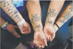  ??  ?? New tattoos adorn the arms of Martinez family members, from left, Katie, Melissa, Olivia and Erika. They want to forever memorializ­e Isabella.