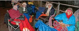 ??  ?? ALL WRAPPED UP: Diehard Strictly fans keep warm inside sleeping bags and blankets. Top: The queue outside the main gate at Elstree on Friday night