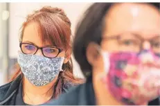  ?? FOTO: DPA ?? Mitarbeite­rinnen in einem Supermarkt tragen Mund- und Nasenmaske­n, während sie vor der Ladenöffnu­ng die Regale mit Waren bestücken.